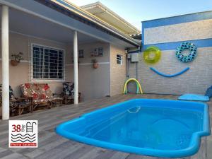 uma grande piscina azul num deque com uma casa em Casa Cores Guaratuba Piscina Aquecida WiFi Rápido TV Smart em Guaratuba
