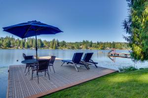 une terrasse avec une table, des chaises et un parasol dans l'établissement Lakefront Snohomish Cottage with Private Dock!, à Snohomish