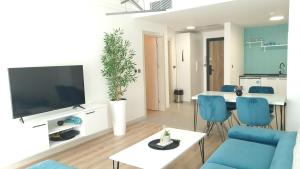 a living room with a blue couch and a tv at Horizon Blue Apartment & Spa in Skopje +5 photos