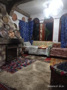 a living room with a couch and a fireplace at Maison d'hotes Ait Bou Izryane in Timoulilt