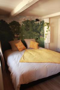 1 dormitorio con 1 cama con una pintura en la pared en Madame Bergamote en Nancy