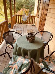 una mesa y sillas en un porche con hamaca en Agroturystyka Uroki Roztocza en Zamość