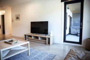 Una sala de estar con un televisor de pantalla plana y una mesa. en Revy Mountain Retreat, en Revelstoke