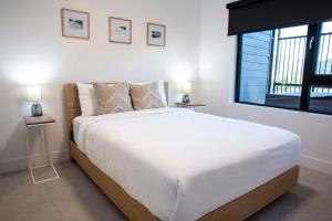 Un dormitorio con una gran cama blanca y una ventana. en Revy Mountain Retreat, en Revelstoke
