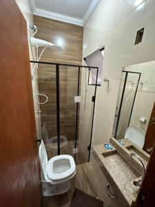 a bathroom with a toilet and a sink at Suítes 4 Estações in São Thomé das Letras