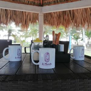 een tafel met koffiemokken erop bij La Morada, una ventana al golfo - Hotel boutique in Monte Gordo