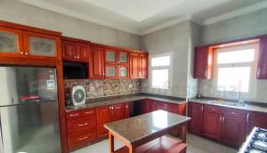 a kitchen with wooden cabinets and a table in it at North coast Sedra resort villa قرية سيدرا الساحل الشمالي in Alexandria