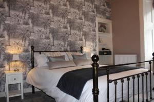 sypialnia z dużym łóżkiem z malowidłem ściennym w obiekcie Cameronian Apartment w mieście Stirling