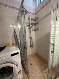 uma máquina de lavar roupa na casa de banho com um chuveiro em Elegant Escapes 3 em Atenas