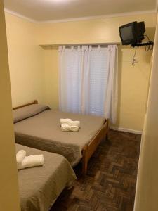 um quarto com duas camas e uma televisão e uma televisão em Hotel gade em Mar del Plata