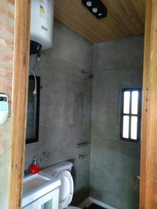 baño con aseo y lavabo y ventana en Cabaña LA PEDRERA - Pileta y a metros del Rio en Bialet Massé