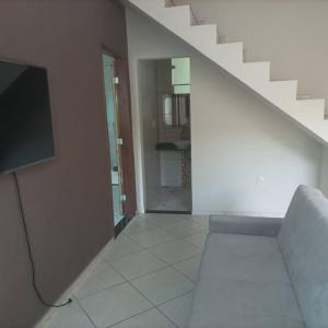 a living room with a couch and a staircase at Casa Cidade Nova, Jd Belvedere. in Volta Redonda