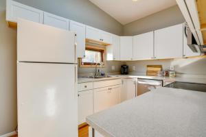 a kitchen with white cabinets and a white refrigerator at Pet-Friendly Anchorage Home - 8 Mi to Downtown! in Anchorage