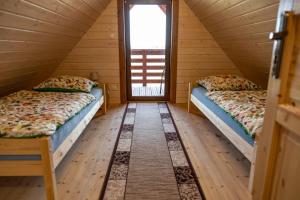 twee bedden in een kamer met een raam bij BANIA NA CZASIE in Szyldak