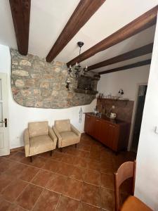 a living room with two chairs and a stone wall at Casa Maja in Koločep