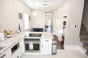 a kitchen with white counters and a staircase at Treme Treasure in New Orleans