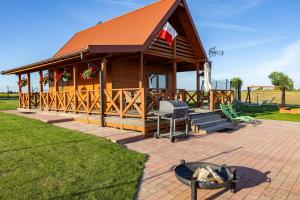 een grote houten hut met een grill en een speeltuin bij BANIA NA CZASIE in Szyldak