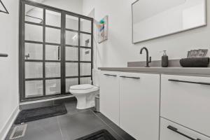 a white bathroom with a toilet and a window at Stylish Nexus in Columbus
