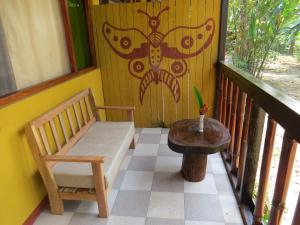 a porch with a bench and a table on a balcony at Paraiso Pilcopata Inn in Pillcopata