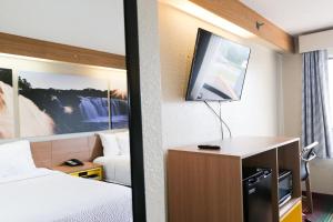 Habitación de hotel con cama y TV en Days Inn by Wyndham Flint/Bishop International Airport, en Flint