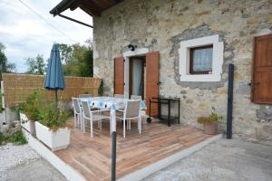 een patio met een tafel en stoelen en een parasol bij Gîte de Crêt Vial in Alby