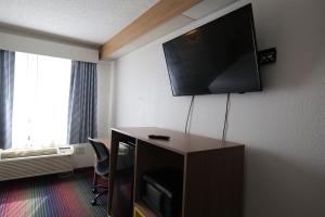 a hotel room with a flat screen tv on the wall at Days Inn by Wyndham Flint/Bishop International Airport in Flint