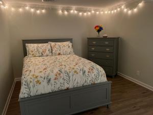 a bedroom with a bed and a dresser and lights at My little place in Stratford