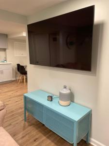 My little place في ستراتفورد: غرفة معيشة مع طاولة زرقاء وتلفزيون