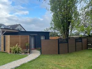 a backyard with a fence and a house at Cabane paisible à 15 min du futuroscope in Saint-Julien-lʼArs