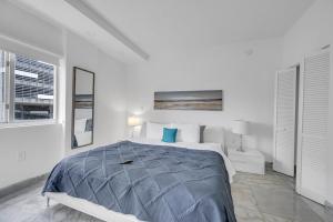 a white bedroom with a large bed and a window at Subtle 2 Bed in Edgewater near Downtown With Free Parking in Miami