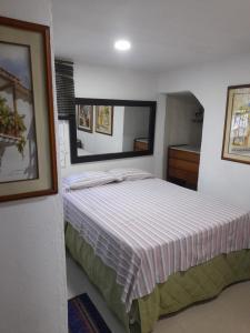 ein Schlafzimmer mit einem Bett mit einer gestreiften Decke in der Unterkunft Hostal Casa de las Americas in Cartagena de Indias