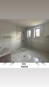 ein Bad mit einer Dusche und einem Waschbecken in der Unterkunft Vila Mik Guesthouse in Săcele