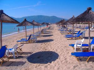a row of chairs and umbrellas on a beach at Sulashome in Tsáyezi