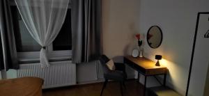a room with a desk and a mirror and a window at Apartman HD in Đakovo