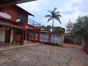 een huis met een hek en een palmboom bij Pousada Central in Santana do Riacho
