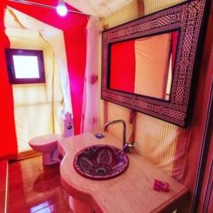 メルズーガにあるMerzouga Luxury Campsのバスルーム(洗面台、壁掛け鏡付)