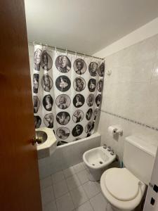 baño con aseo y cortina de ducha con caras. en DEPARTAMENTO EN EL CORAZÓN DE NUEVA CÓRDOBA en Córdoba