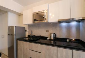 a kitchen with a refrigerator and a microwave at Connect by Wynwood House in Lima