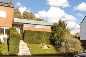 una casa de ladrillo con un jardín delante de ella en De Buidel en Meise