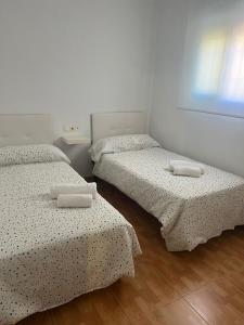 Ce lit se trouve dans un dortoir doté de murs blancs et de parquet. dans l'établissement Guadalora, à Lora del Río