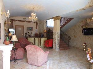 a living room with red chairs and a staircase at Family hotel Tropicana in Ravda