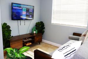 a living room with a couch and a flat screen tv at Luxury Studio Suite close to Tampa Airport in Tampa