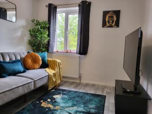 a living room with a couch and a television at Stylish Flat - Perfect location for Contractors, Families, Relocators, Business, Free Parking, Long-Stays in Banbury
