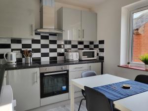 a kitchen with a black and white checkered wall at Stylish Flat - Great location for Contractors, Families, Relocators, Business, Free Parking, Long-Stays in Banbury