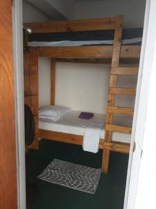a bunk bed in a room with a ladder at Shrimpy's Hostel, Crew Quarters and Laundry Services in Marigot