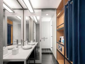 a bathroom with three sinks and a row of mirrors at Aloft Bogotá Airport in Bogotá +70 photos