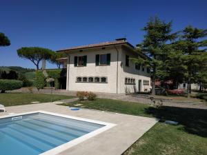 une maison avec une piscine en face d'une maison dans l'établissement Villa Paola Holidays, à SantʼAngelo in Vado