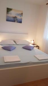 een groot wit bed met drie kussens erop bij Apartment in Lopar with Two-Bedrooms 3 in Lopar