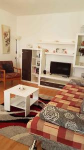 a living room with a couch a table and a tv at Apartment in Lopar with Two-Bedrooms 1 in Lopar