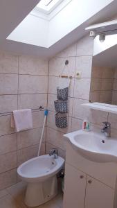 La salle de bains est pourvue de toilettes blanches et d'un lavabo. dans l'établissement Apartment in Lopar with Two-Bedrooms 1, à Lopar